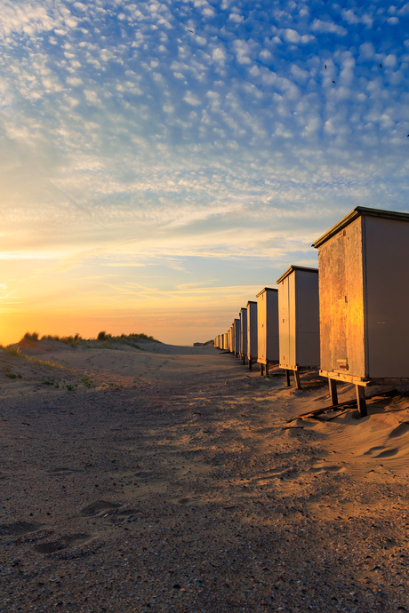 Strandhuisjes belicht door de laatste zonnestralen van de dag