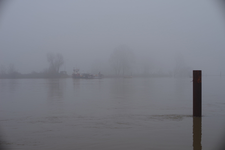 Pont in de mist bij hoog water