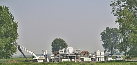 Het grote baggerschip, een stuk wal weg.