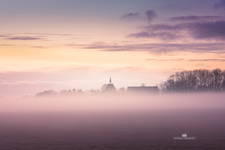 Kerkje in de mist bij zonsopkomst