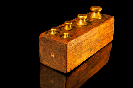 koperen gewichten in een houten blok