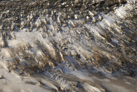 Wind en sneeuw op het strand