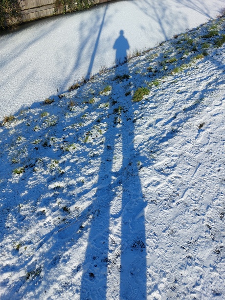 Lange schaduw benen in sneeuw.