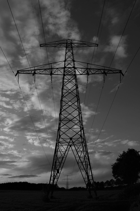 Hoogspanningsmast in zwart-wit.
