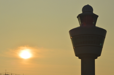 Luchtverkeerstoren Schiphol met ondergaande zon