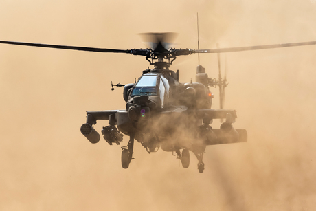 Apache helikopter bijt door het stof heen