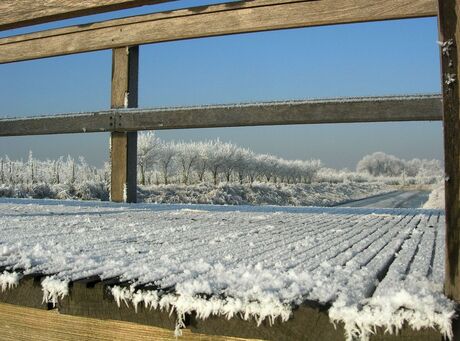 Besneeuwde houten brug