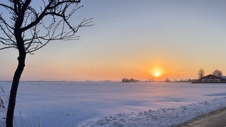 Sneeuwlandschap in de ondergaande zon.