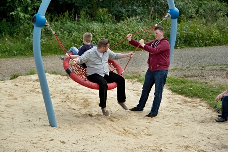 Grote kinderen bij de schommel.