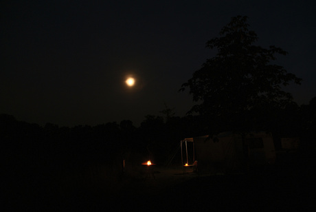 Kamperen bij volle maan met kampvuur