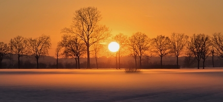 Zonsondergang over besneeuwde landerijen