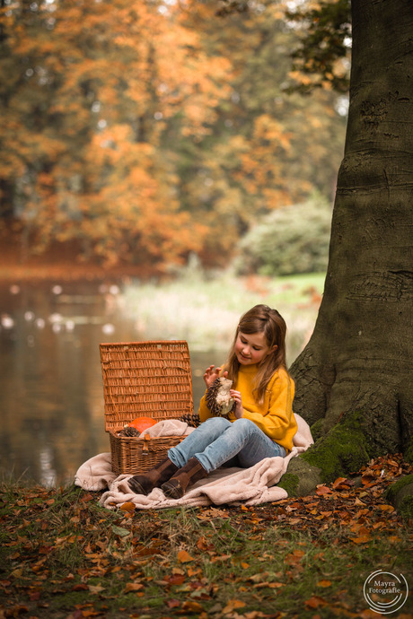 Meisje met egeltje in herfst bos