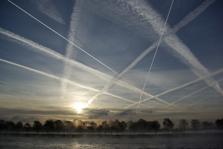 Vliegtuigstrepen bij zonsopgang