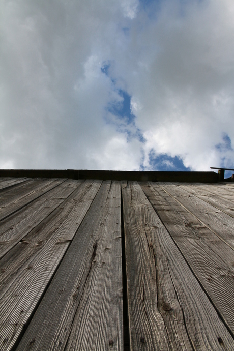 Houten schuur onder wolkenspel