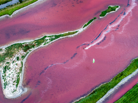 Kitesurfer op roze meer