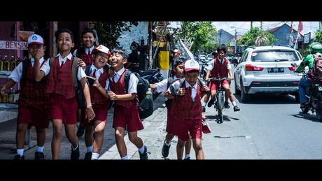 Schoolkinderen in Bali. Gecropped op kinematische afmetingen om het te laten lijken alsof het een scene uit een film is.