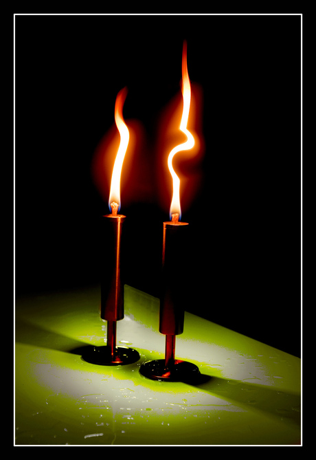 Twee brandende kaarsen.