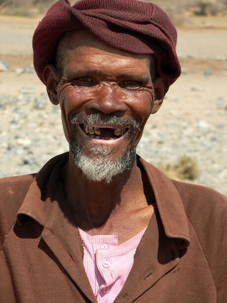 Lachende arme man in Namibië