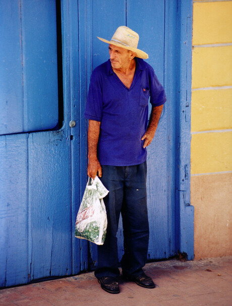 Man met hoed en plastic tas