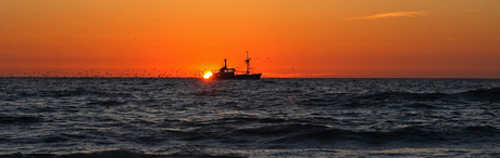 Vissersboot bij zonsondergang