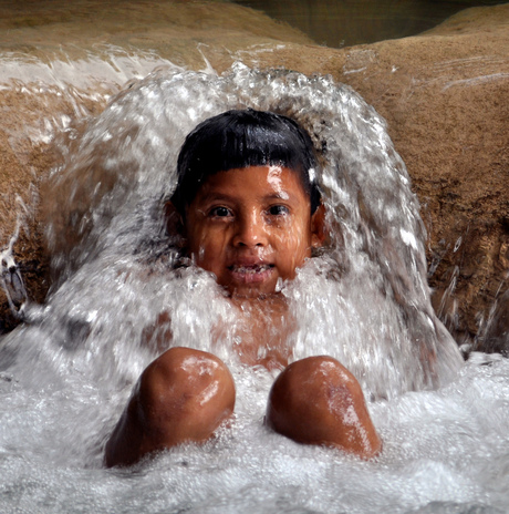 Mayan playing in waterfall