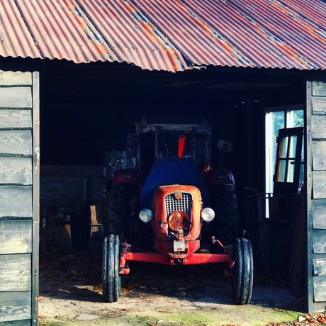 Oude tractor in loods