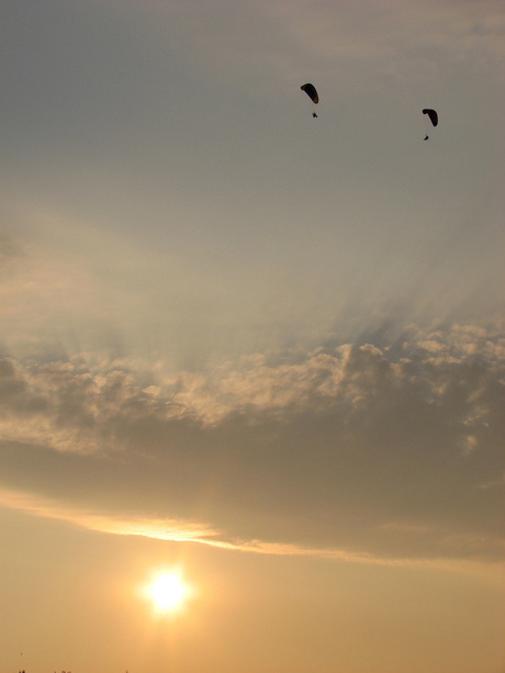 parachuters bij zonsondergang