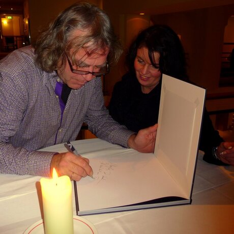 Govert de Roos signeert zijn boek.