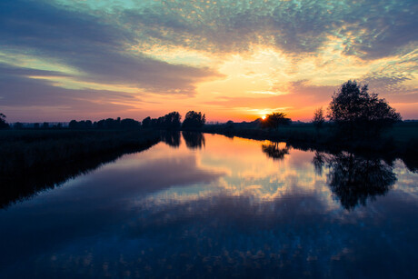 Zonsondergang boven het water.