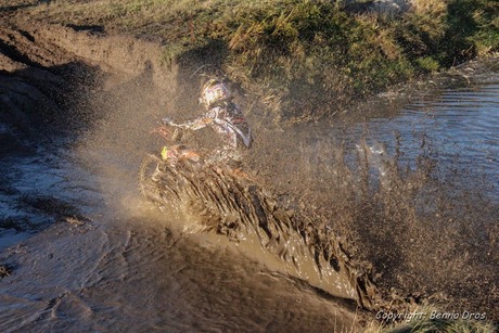 Motorcrosser scheurt vol door een prut sloot heen