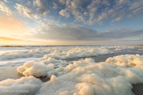 Schuimvlokken op het strand 