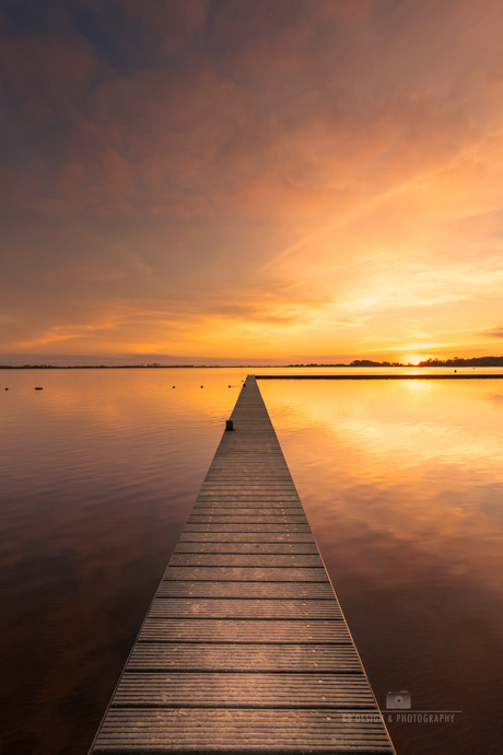 Zonsondergang en het meer met een lange steiger