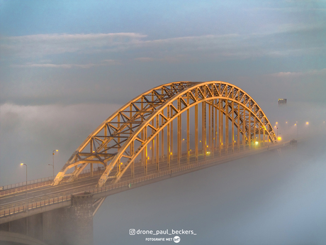 De Waalbrug in de ochtendzon tijdens een mistig begin van de dag.