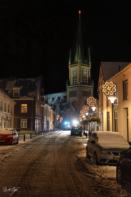 Winternacht met kerk in het dorpshart