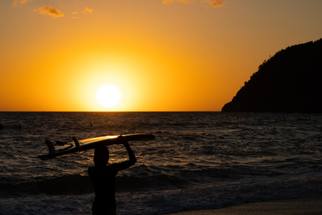 Surfers tijdens zonsondergang