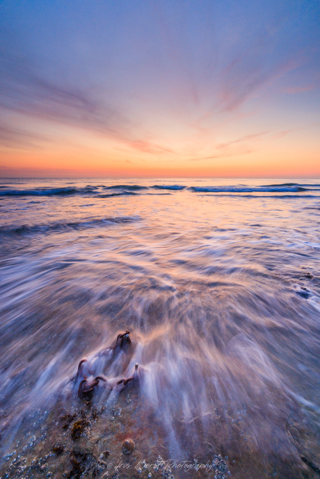 Zonsondergang aan de Opaalkust met beweging in de zee en een bootketting als focuspunt