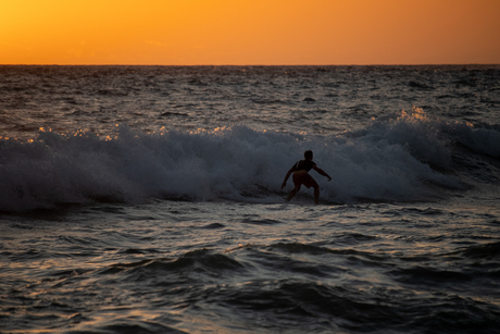 Surfen tijdens de zonsondergang