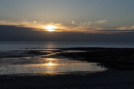Ondergaande zon bij laagwater