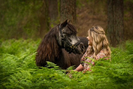 Meisje met haar pony in een sprookjesbos