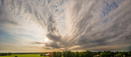 Achter de wolken gaat de zon onder