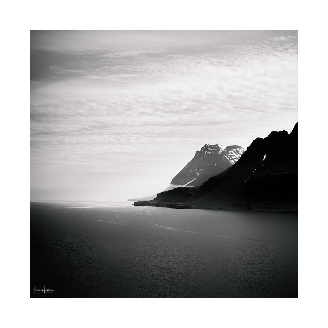 Desolation XII - Een strand aan een fjord in de IJslandse Westfjorden. - foto door FHoogeboom op 23-12-2022 - locatie: Westfjords, IJsland - deze foto bevat: westfjorden, ijsland, landschap, zee, oceaan, fjord, vierkant, zwart-wit, donker, somber, bergen, lucht, wolken, tonaliteit, minimalisme, kunst, monochroom, contrast, nordic, arctisch, canon, canon eos 6d, ef24-105mm f/4l is usm, iso 100, diafragma ƒ/11, sluitertijd 1/250s, brandpuntafstand 55mm, water, lucht, berg, natuurlijk landschap, wolk, zwart en wit, rechthoek, horizon, landschap, helling