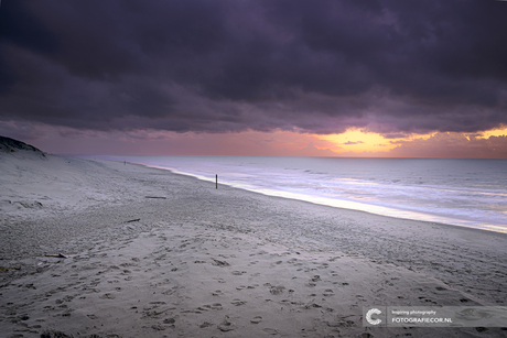 Strandwandeling bij zonsondergang aan de kust van Texel