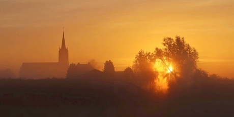 Mistig landschap bij zonsopkomst