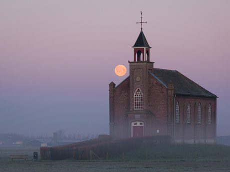 Volle maan tijdens zonsopkomst