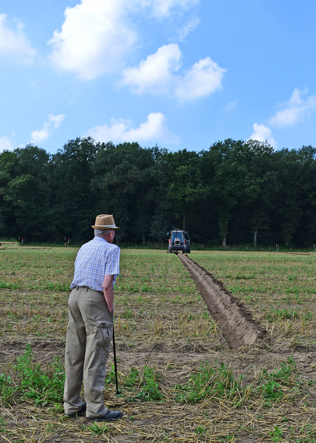 vader keurt trekkerwerk zoon