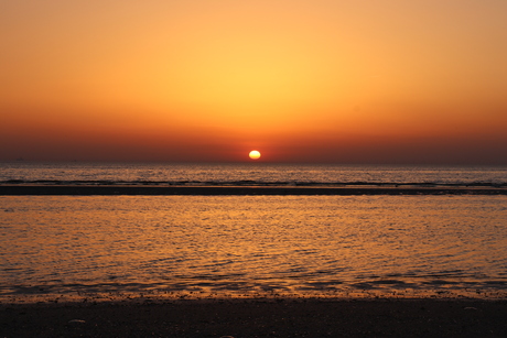 Zon zakt in het water