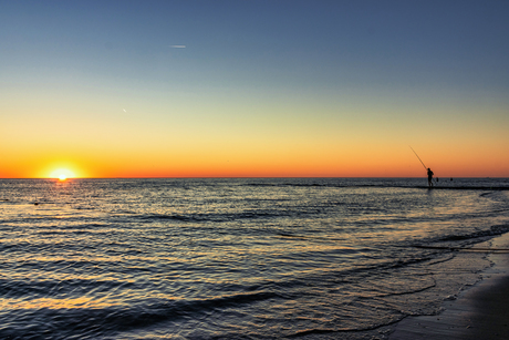 Visser bij zonsondergang