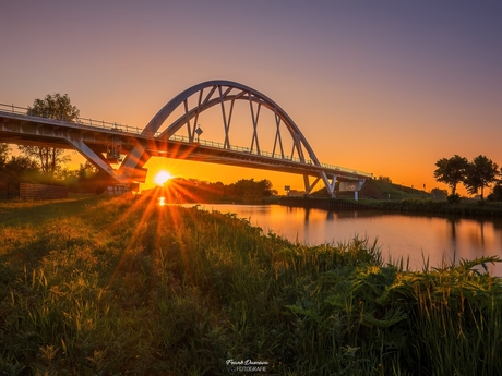 De zonsondergang gevangen onder de Walfridusbrug.