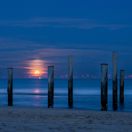 Palendorp Petten bij bijna volle ondergaande maan